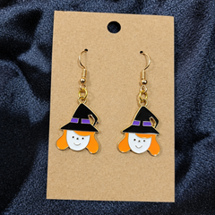 Smiling witch girl enamel drop earrings on kraft card
