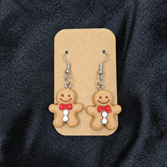 Woman wearing gingerbread man drop earrings