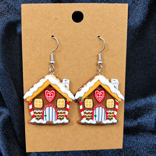 Woman wearing gingerbread house drop earrings