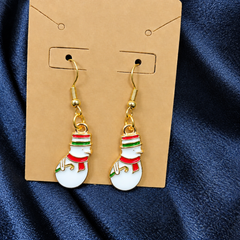 Woman wearing enamel snowman drop earrings
