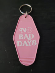 No Bad Days pink motel-style keychain with bold white lettering and smiley face in the O