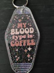 My Blood Type Is Coffee black rainbow glitter motel-style keychain with pink retro lettering and sparkle diamond cutouts