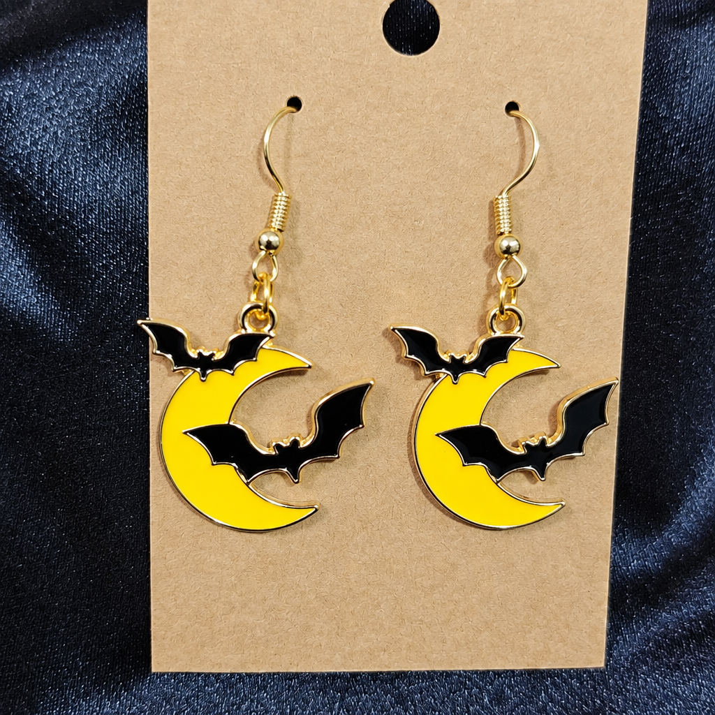 Woman wearing bat and moon enamel drop earrings