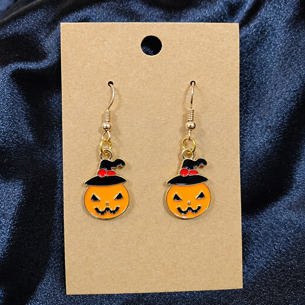 Woman wearing witch hat pumpkin enamel drop earrings