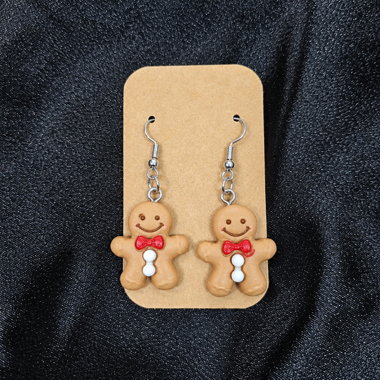 Woman wearing gingerbread man drop earrings