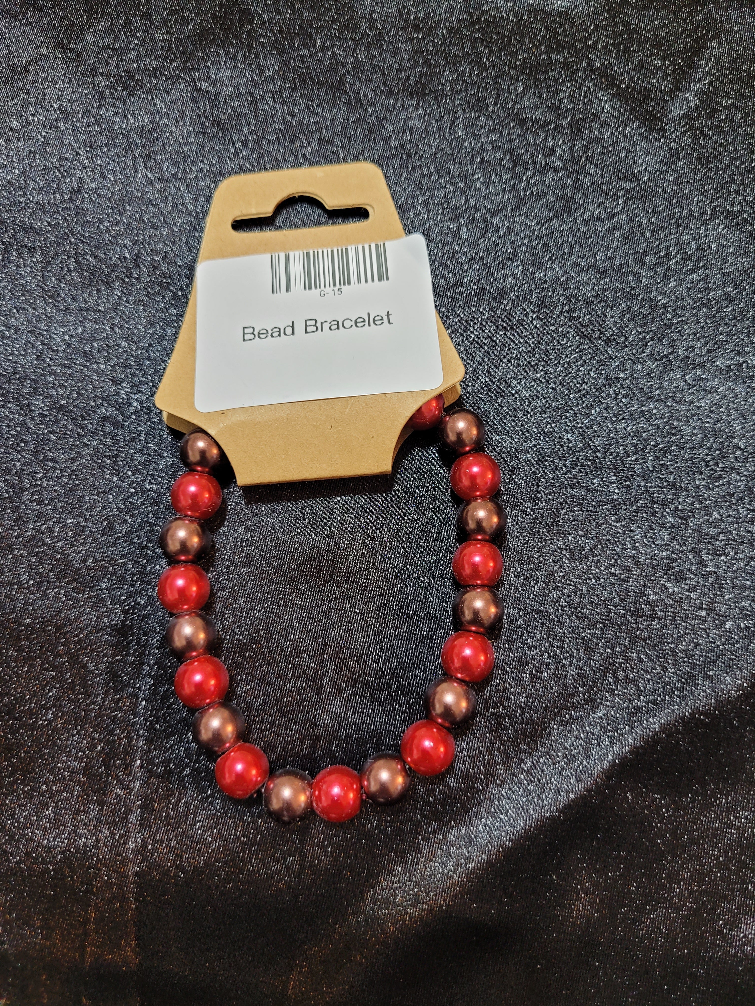 Red and bronze pearlescent bead stretch bracelet on display card