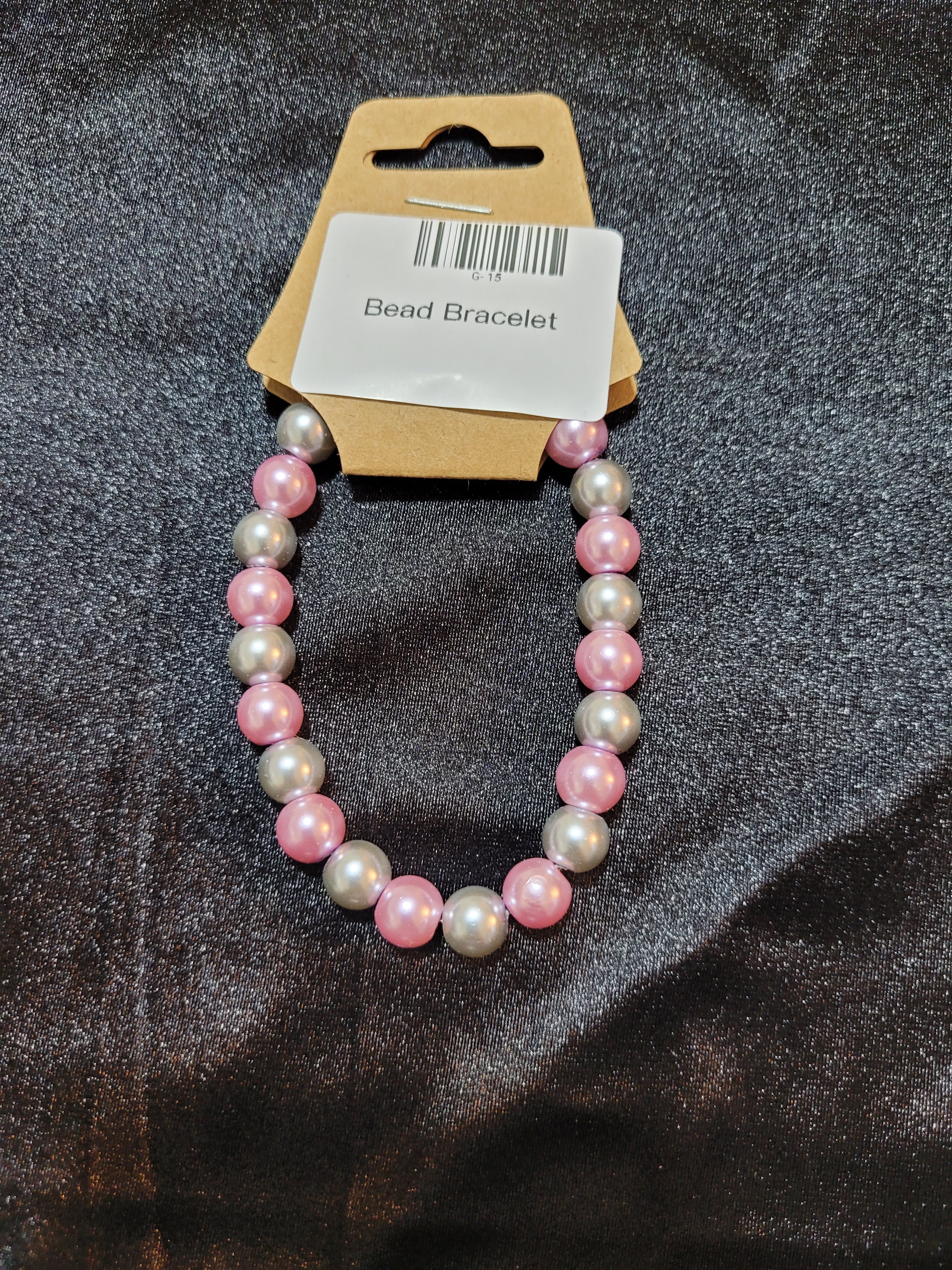 Pink and silver pearlescent bead stretch bracelet on display card