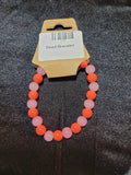 Coral orange and soft pink bead stretch bracelet on display card