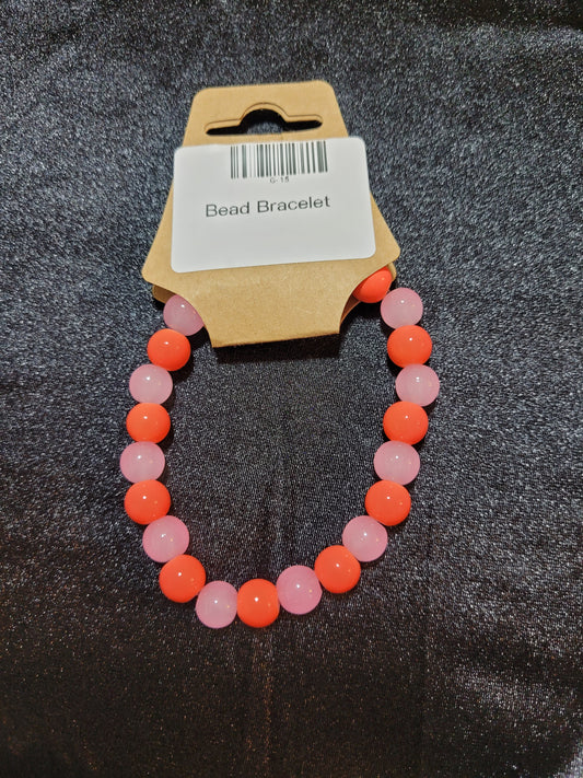 Coral orange and soft pink bead stretch bracelet on display card