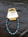 Teal and silver metallic bead stretch bracelet on display card