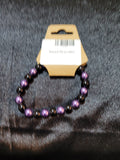 Purple and black metallic bead stretch bracelet on display card