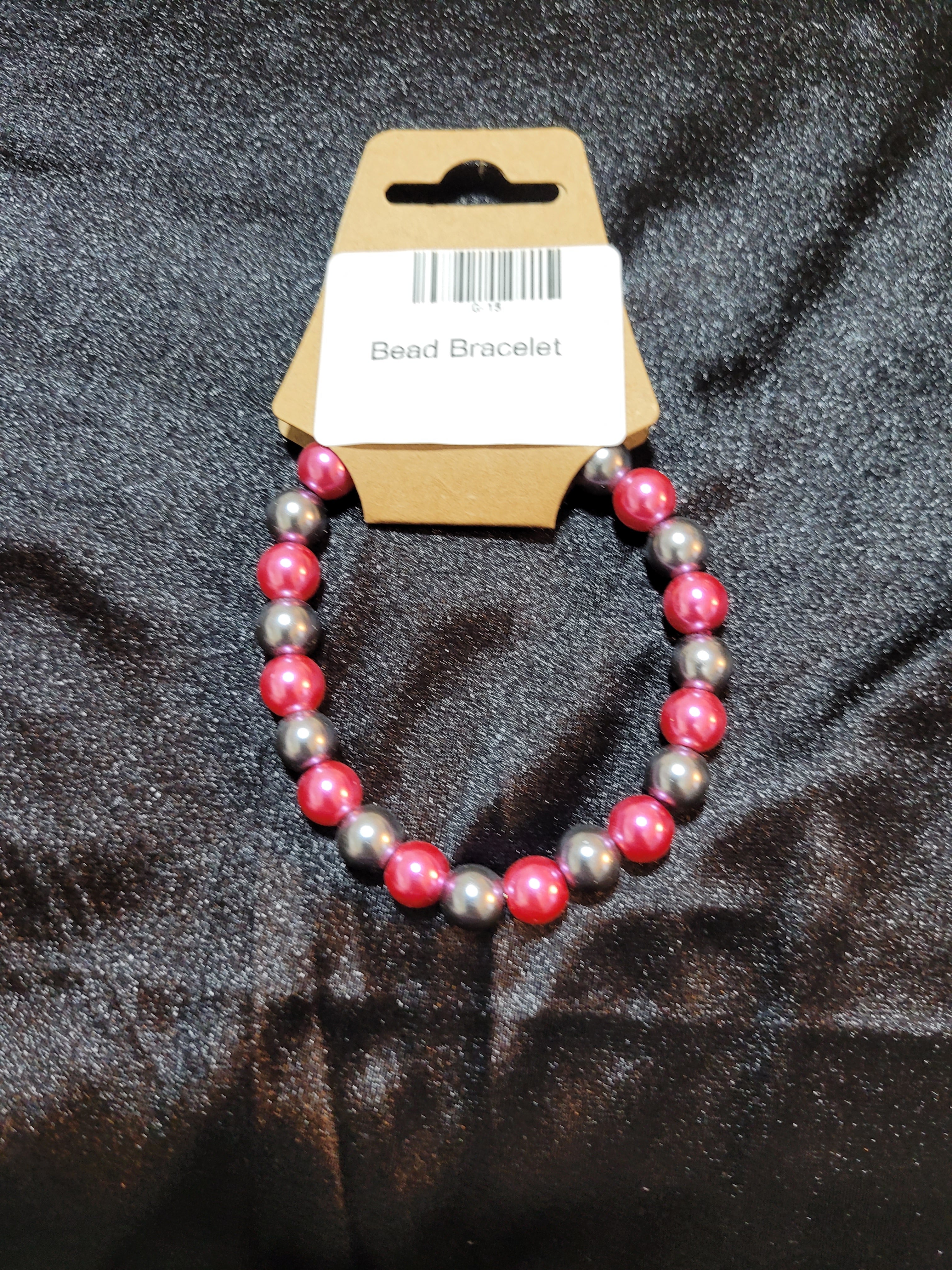 Hot pink and silver metallic bead stretch bracelet on display card