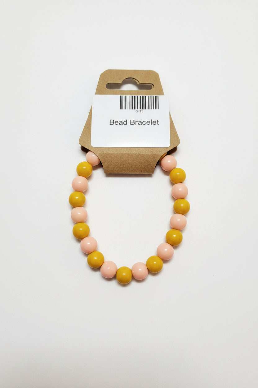 Mustard yellow and blush pink bead stretch bracelet on display card