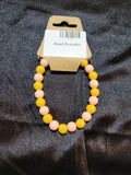 Mustard yellow and blush pink bead stretch bracelet on display card