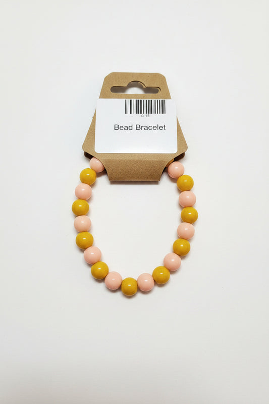 Mustard yellow and blush pink bead stretch bracelet on display card