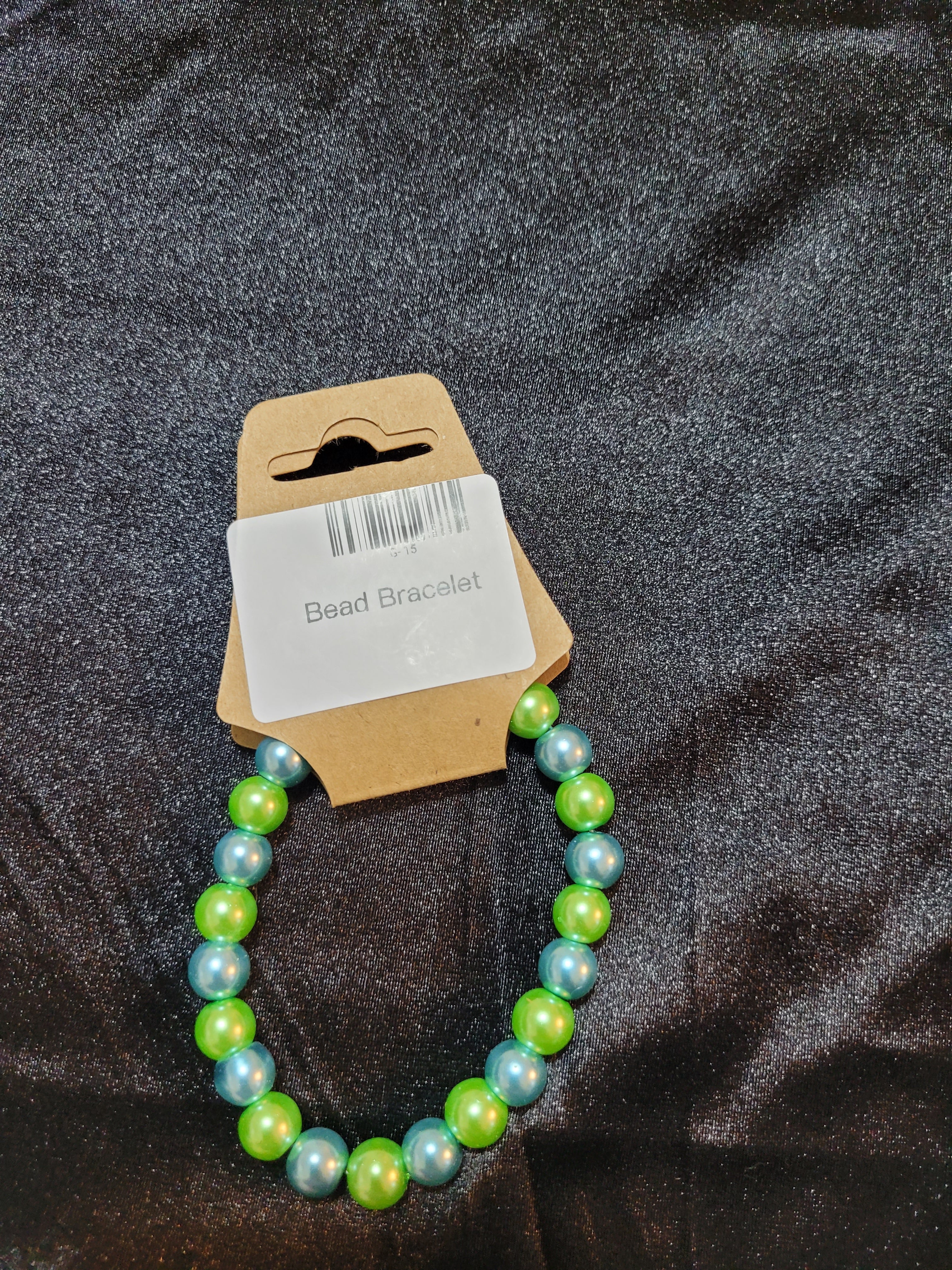 Green and blue pearlescent bead stretch bracelet on display card