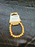 Golden peach pearlescent bead stretch bracelet on display card