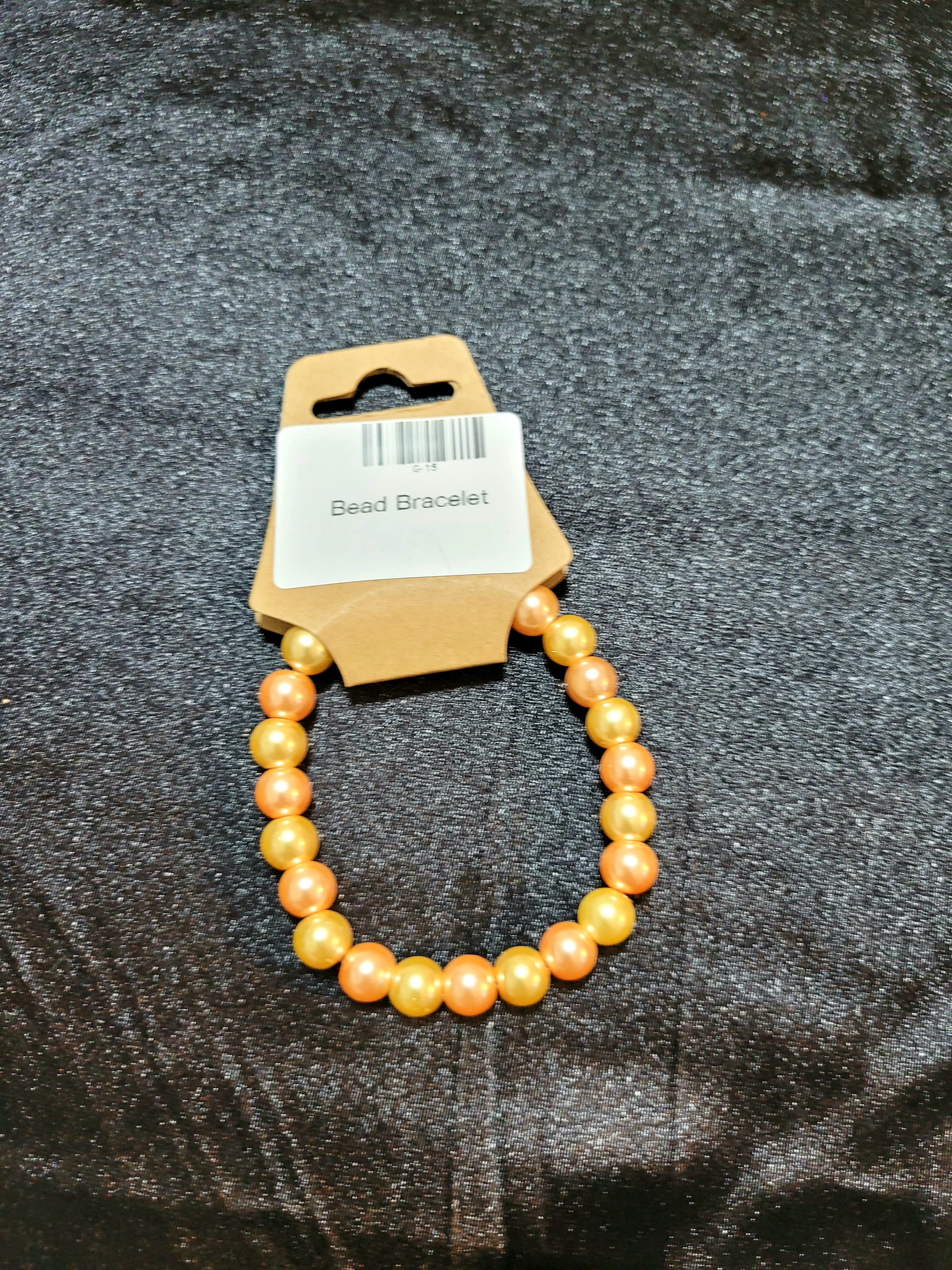Golden peach pearlescent bead stretch bracelet on display card
