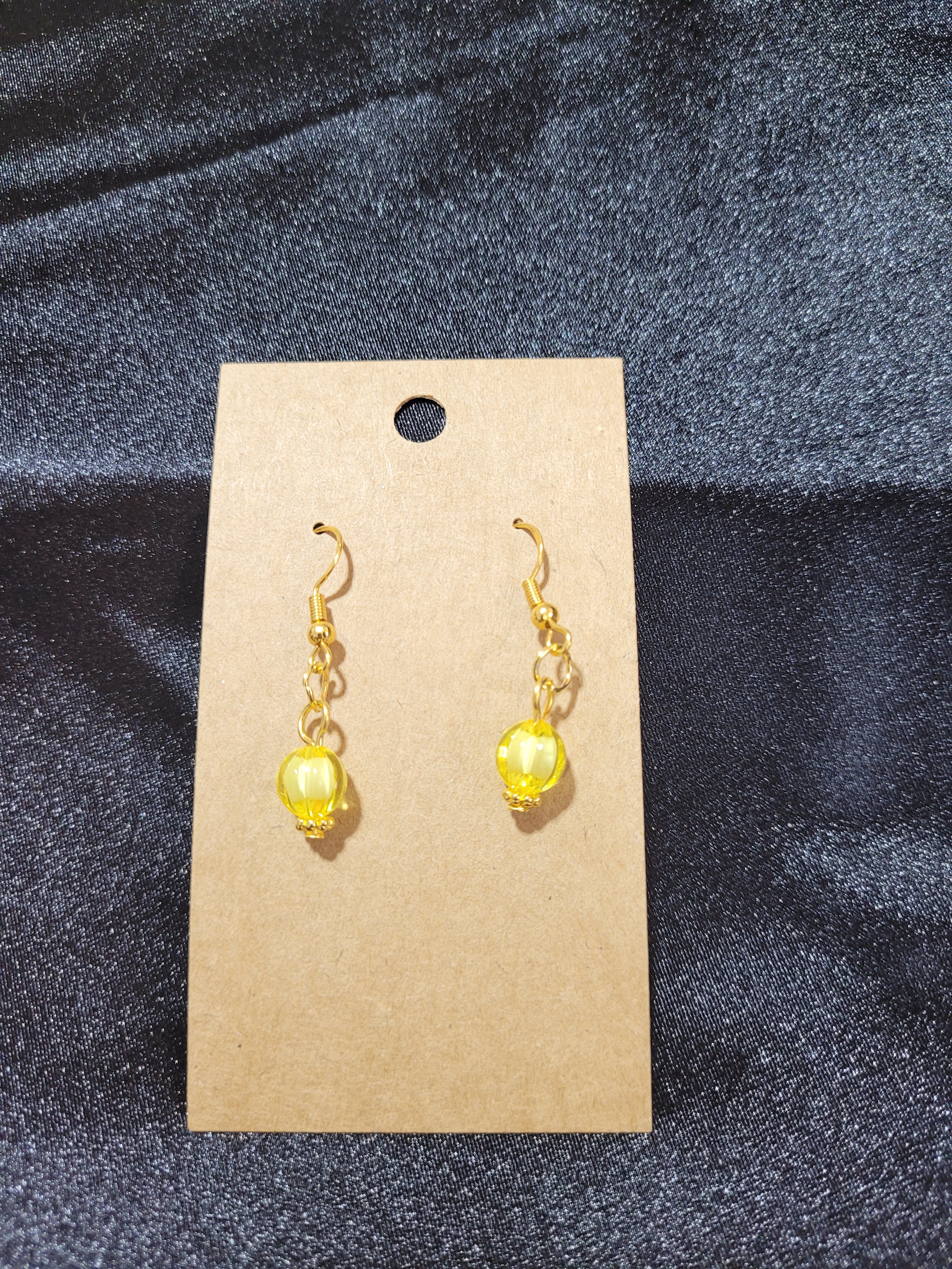 Yellow crystal bead drop earrings on kraft earring card