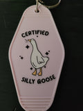 Certified Silly Goose blush pink motel-style keychain with white goose and sparkles