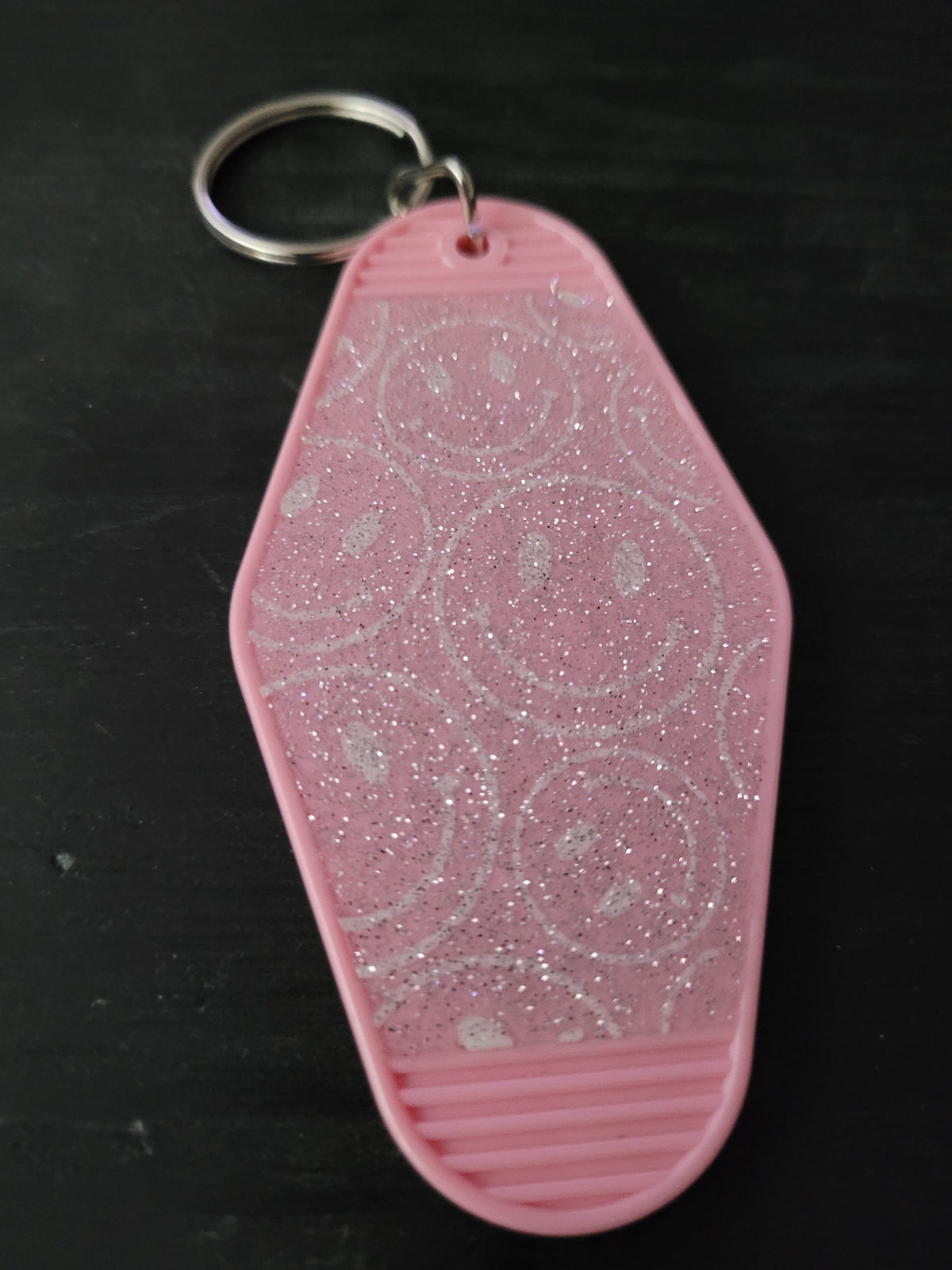 Pink glitter motel-style keychain with iridescent shimmer