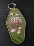 Caffeine Queen olive green motel-style keychain with pink floral accents