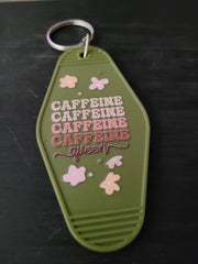 Caffeine Queen olive green motel-style keychain with pink floral accents