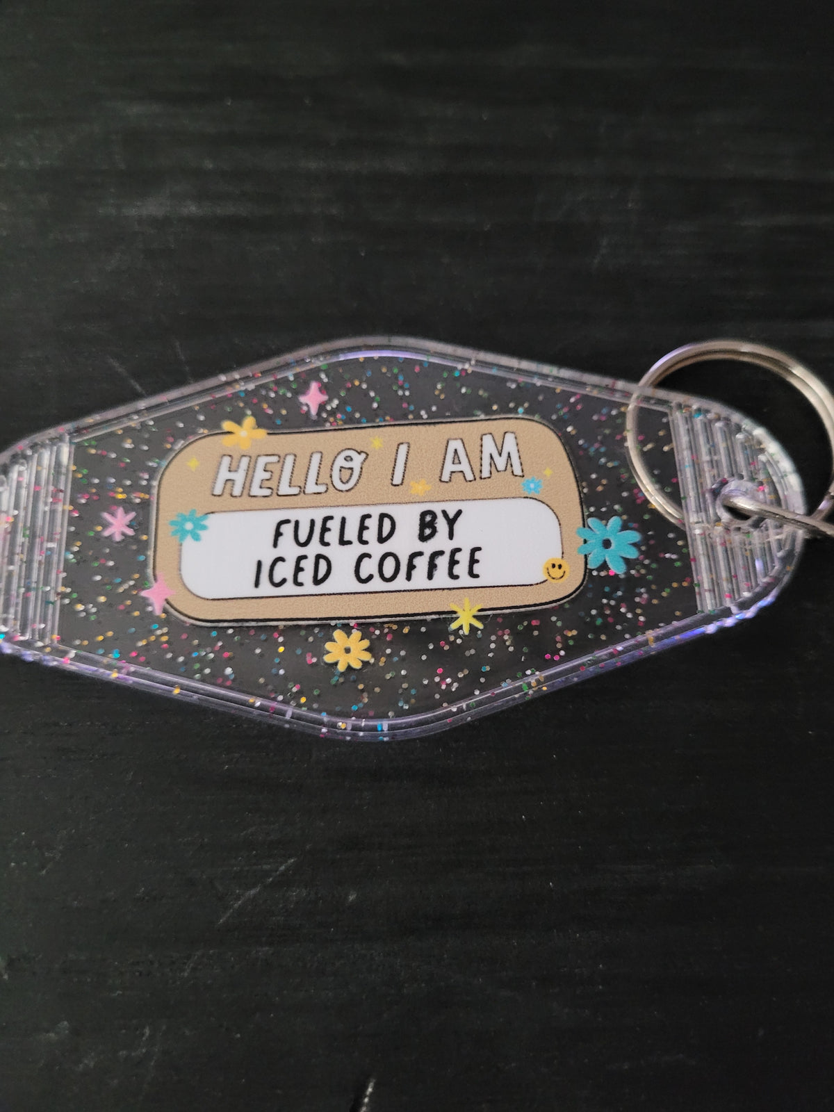 Hello I Am Fueled By Iced Coffee black glitter motel-style keychain with colorful daisies and sparkle stars