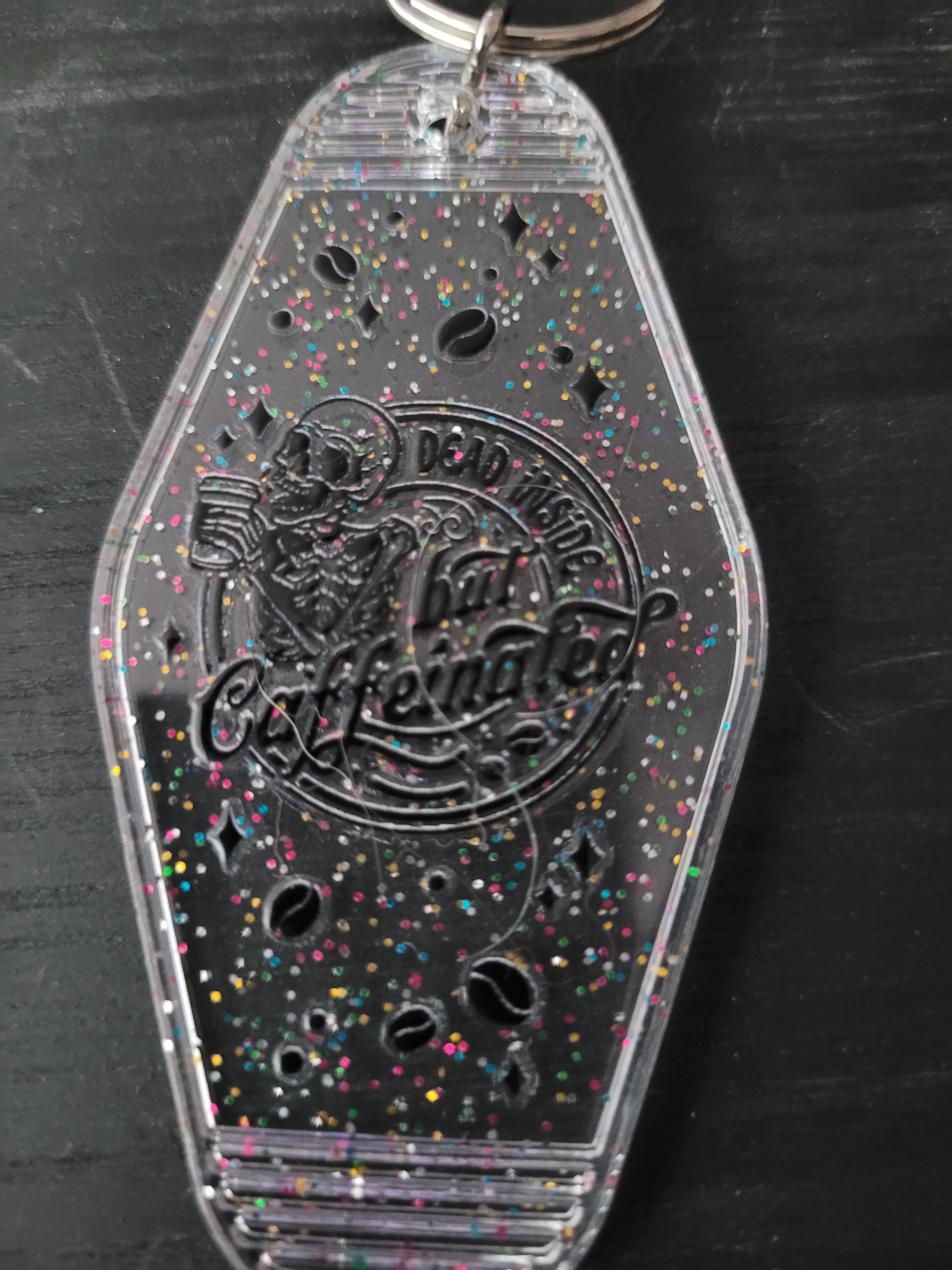 Dead Inside But Caffeinated clear rainbow glitter motel-style keychain with skeleton and coffee bean cutouts