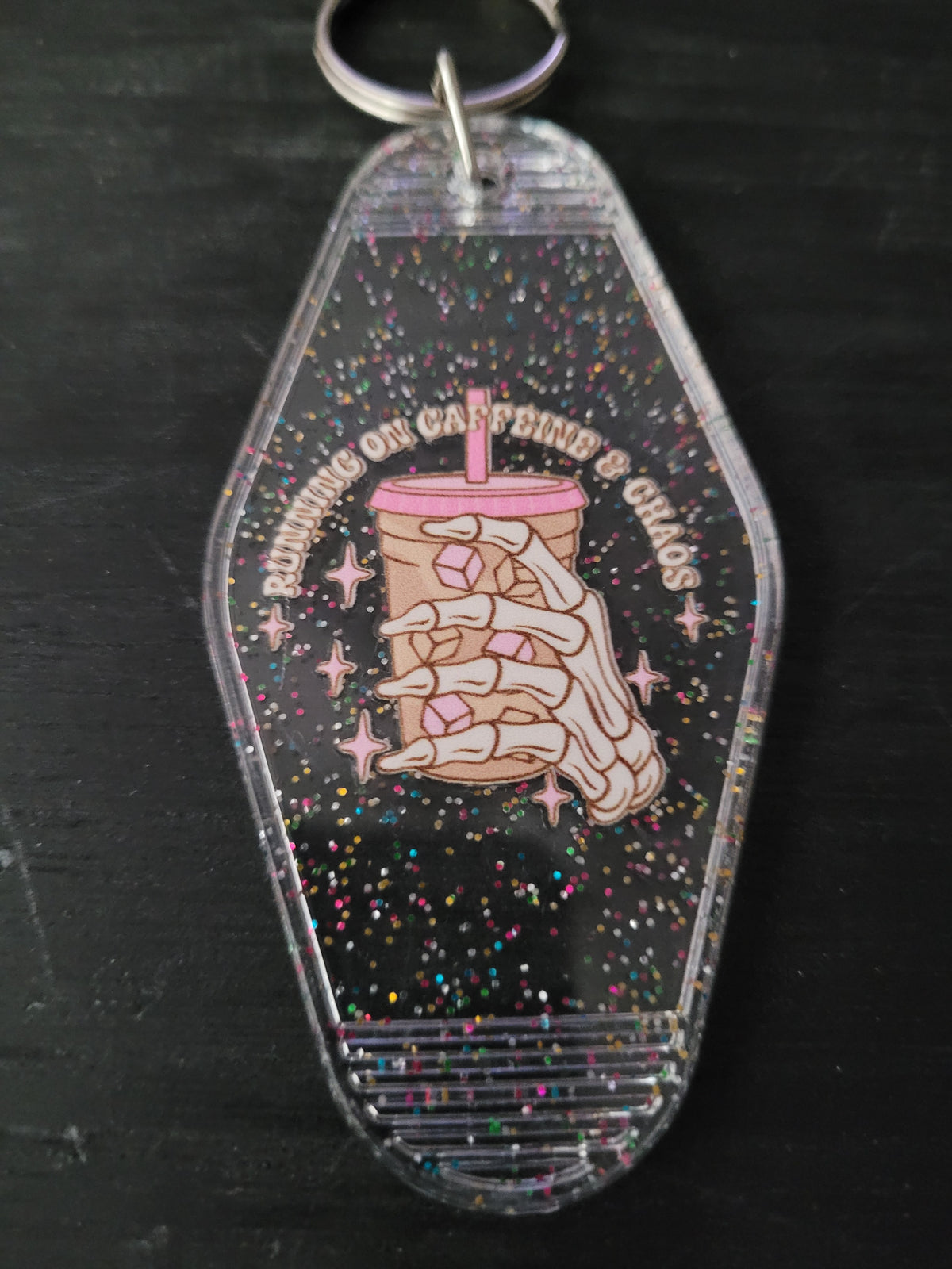 Running On Caffeine and Chaos black rainbow glitter motel-style keychain with skeleton hand holding iced coffee