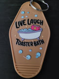 Live Laugh Toaster Bath tan motel-style keychain with bubbly bathtub and smiley toaster illustration