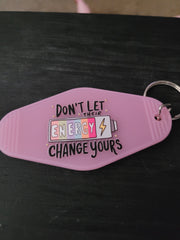 Don't Let Their Energy Change Yours lavender motel-style keychain with colorful battery and lightning bolt