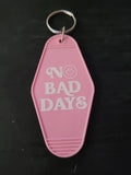No Bad Days pink motel-style keychain with bold white lettering and smiley face in the O