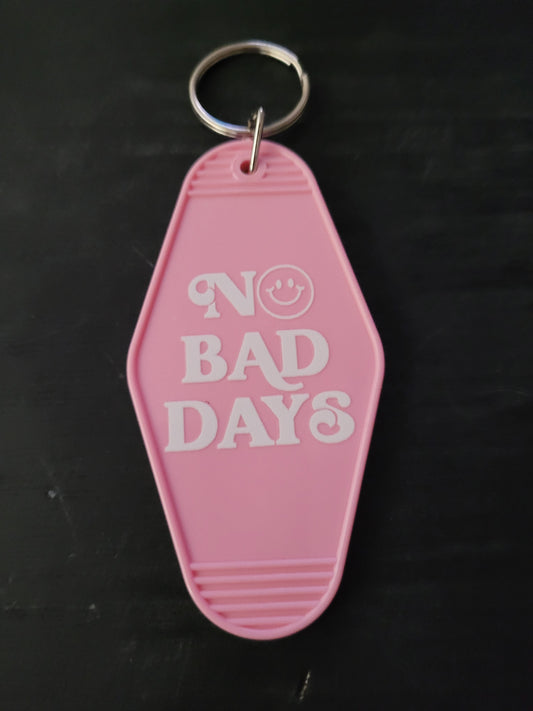 No Bad Days pink motel-style keychain with bold white lettering and smiley face in the O