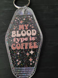 My Blood Type Is Coffee black rainbow glitter motel-style keychain with pink retro lettering and sparkle diamond cutouts