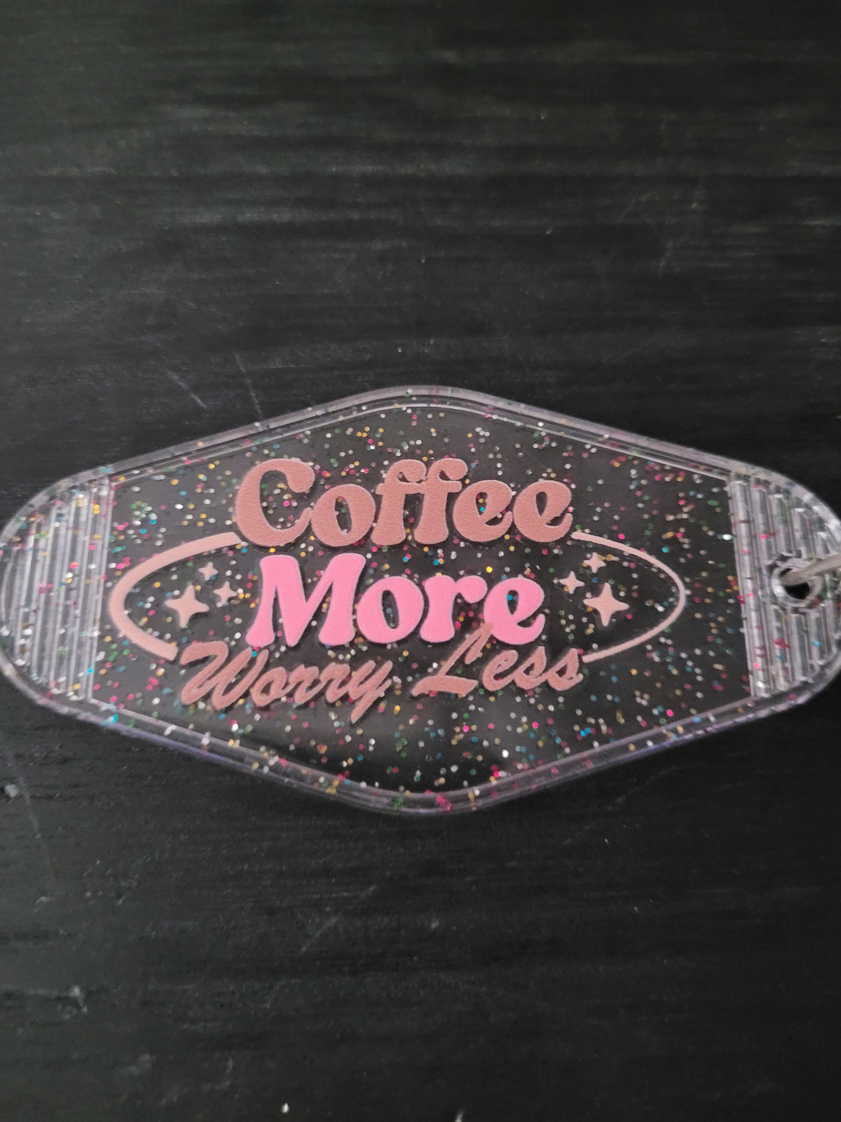 Coffee More Worry Less black rainbow glitter oval motel-style keychain with pink retro script lettering and sparkle star accents