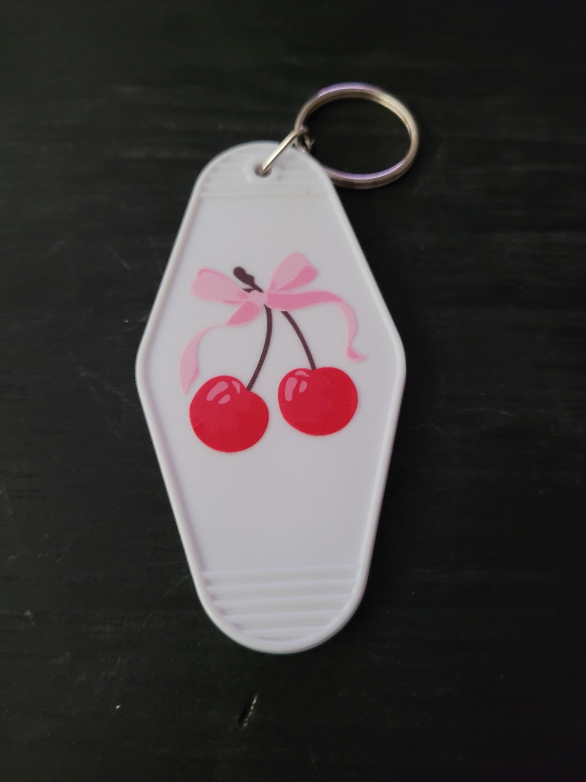 Cherry Bow white motel-style keychain with glossy red cherries tied with a soft pink bow illustration