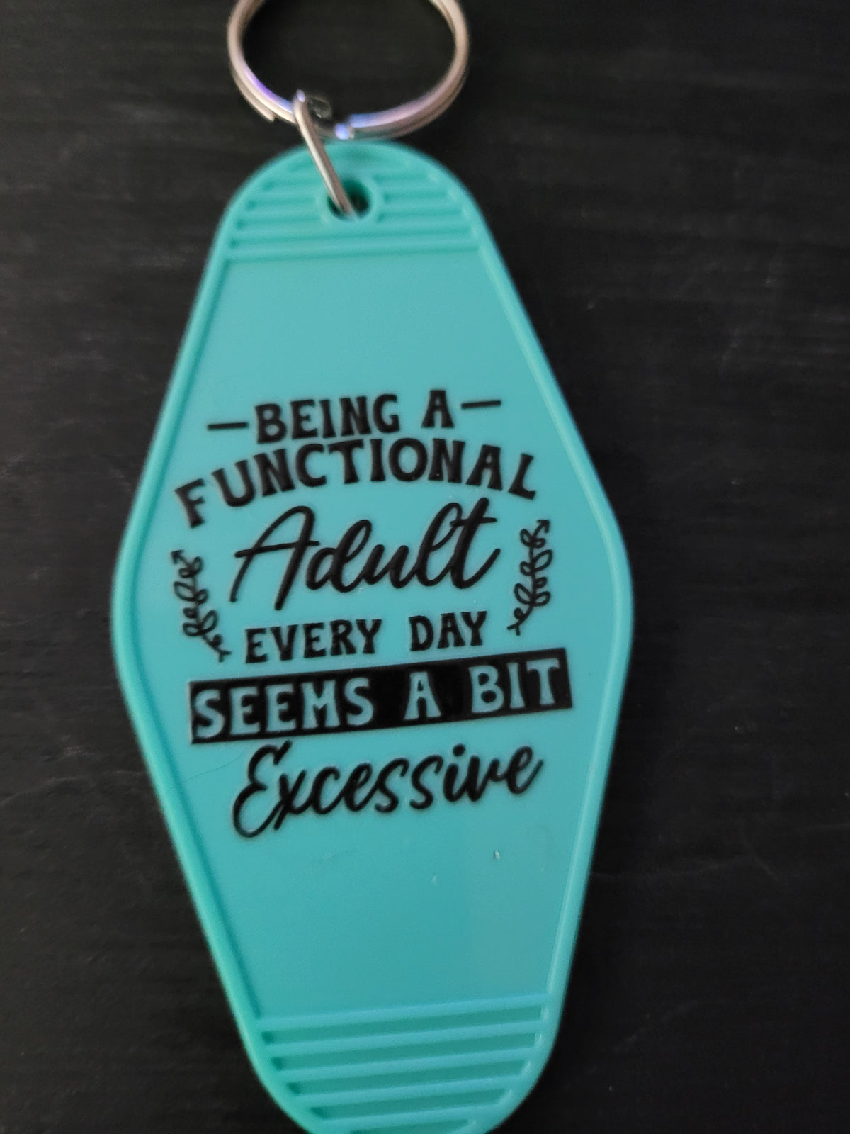 Being A Functional Adult Every Day Seems A Bit Excessive mint teal motel-style keychain with mixed serif script and block lettering and leaf accents